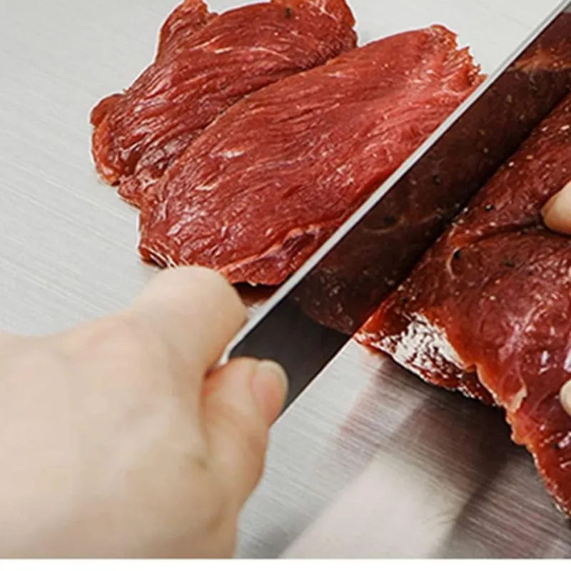 Slicing steak on the brushed titanium board